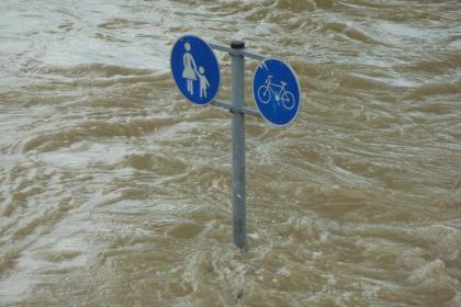 Ein Schild "Fußgänger- und Radweg" ragt aus den Fluten.